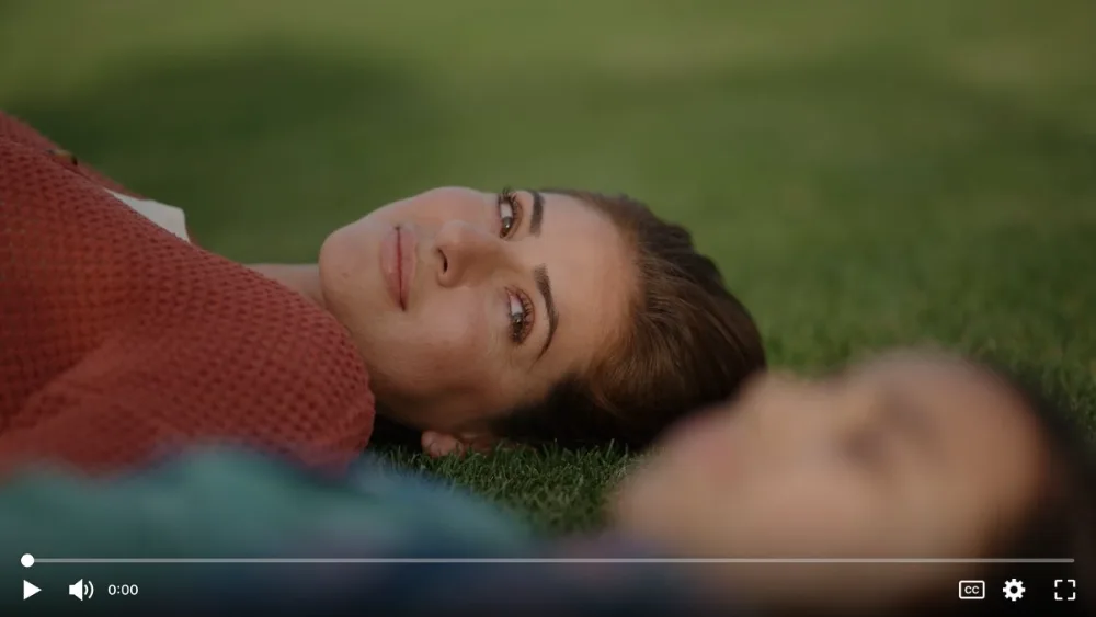 Spanish caregiver video screenshot of woman with a child in grass